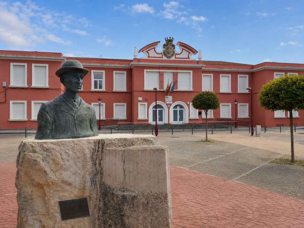 Fachada del IES Bartolomé Cossío de Haro con el monumento situado en la plaza