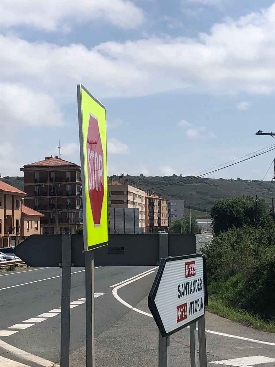 Señal de STOP y paneles hacia Santander y Vitoria junto a una intersección de carretera.
