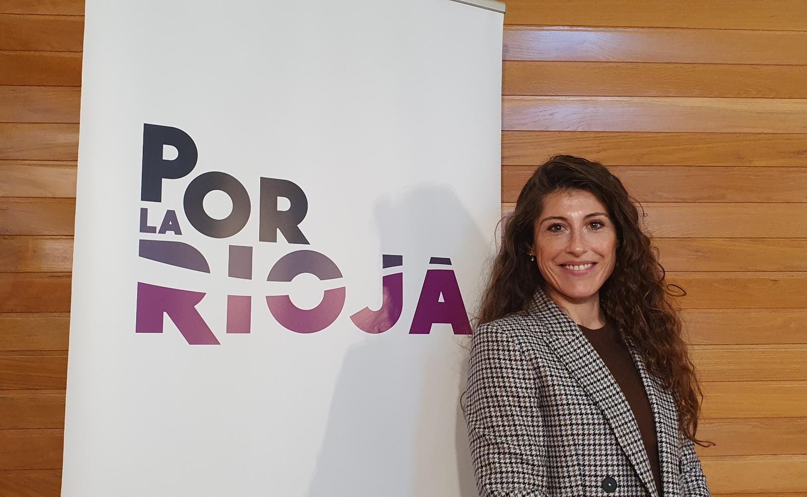 Sonsoles Soriano, candidata a la presidencia de La Rioja, posando junto a un cartel de Por La Rioja