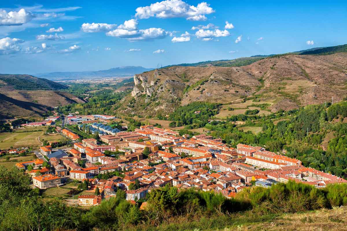 Vista aérea panorámica de Ezcaray, capital de la Comarca del Alto Oja, asentada en un valle rodeado de montañas verdes y paisajes de La Rioja.