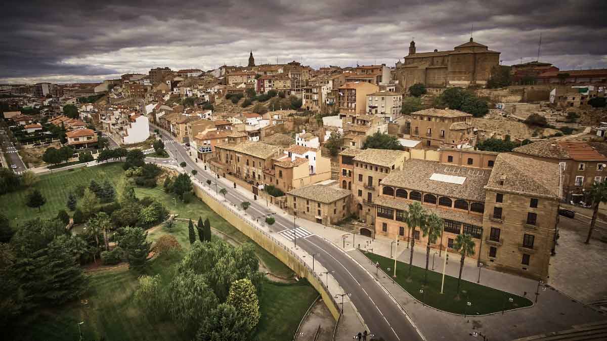 Vista panorámica elevada del municipio de Calahorra, destacando su arquitectura histórica, el entorno urbano de la comarca y zonas verdes bajo un cielo nublado.