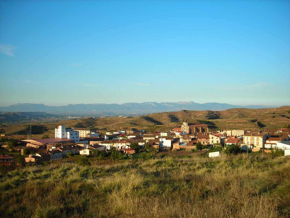 Vista panorámica de Camprovín, con el casco urbano, la torre de la iglesia y el valle del Najerilla al fondo.