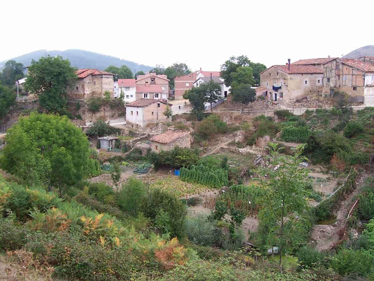 Vista del casco urbano de Pazuengos con huertas, casas tradicionales y paisaje de montaña