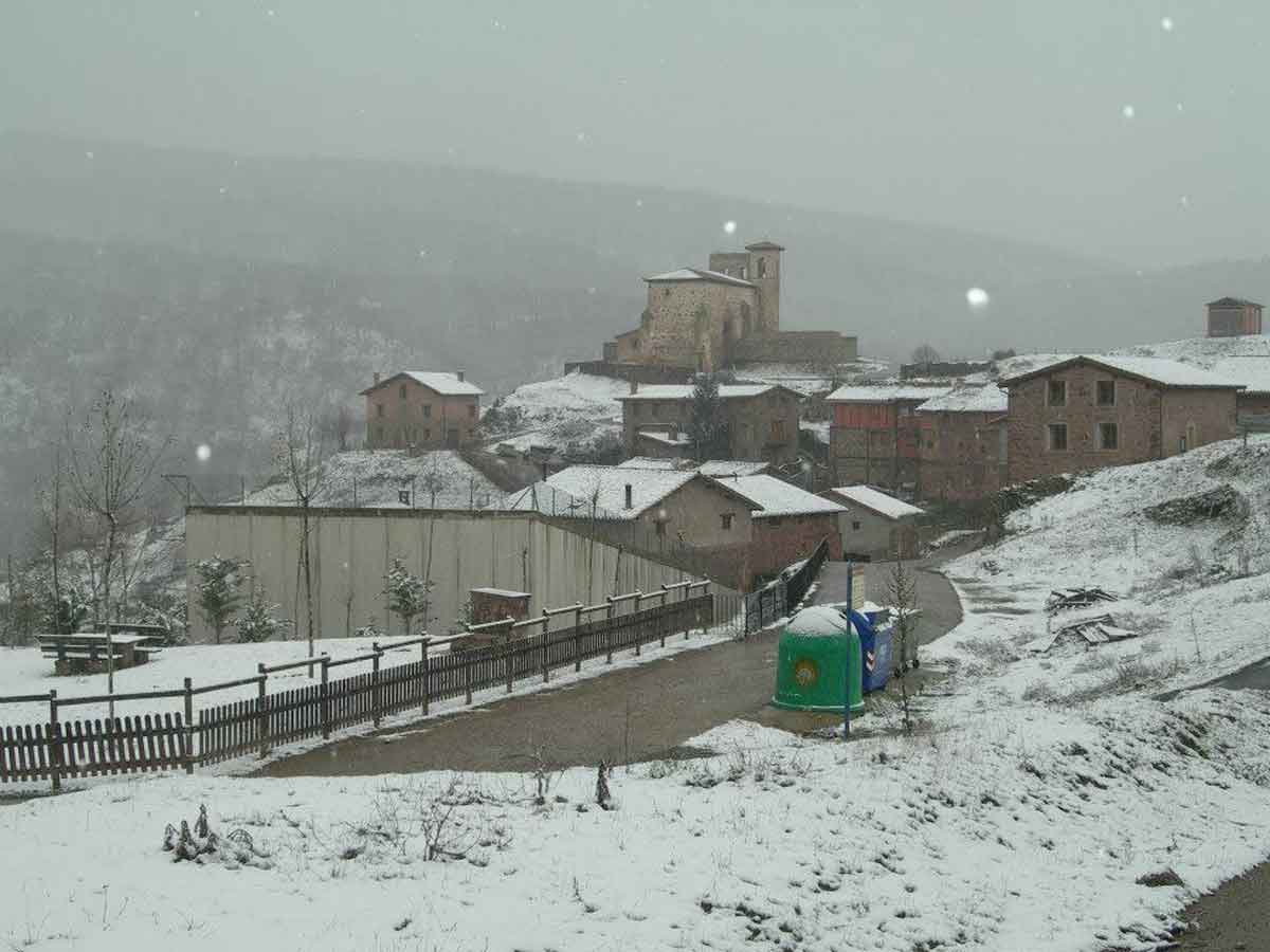Vista nevada de Pinillos con la iglesia y el paisaje del Camero Nuevo