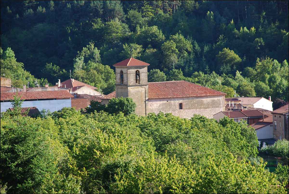 Iglesia de Santurdejo rodeada de vegetación y paisaje natural de la Rioja Alta