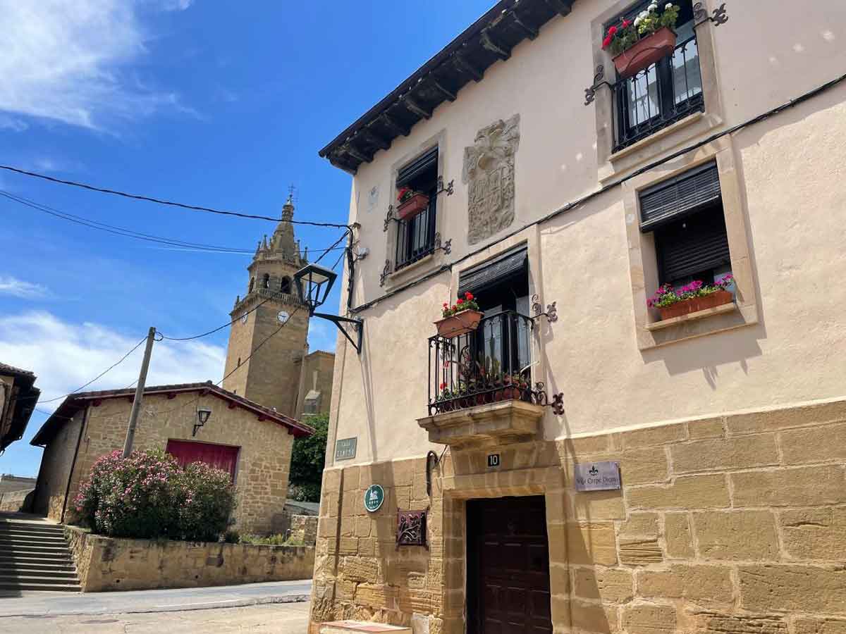 Calle del casco urbano de Zarratón con casas tradicionales y la torre de la iglesia de la Asunción al fondo